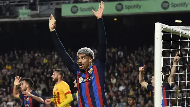 Reaksi bek Barcelona, Ronald Araujo atas keputusan wasit saat menghadapi Girona pada laga Liga Spanyol 2022/2023 di Camp Nou Stadium, Barcelona (10/4/2023). Ronald Araujo yang berpaspor Uruguay merupakan jebolan La Masia yang dipromosikan ke tim utama Barcelona sejak awal musim 2020/2021. Perannya amat sentral di posisi bek tengah Barcelona. Hingga kini ia telah tampil dalam 113 laga di semua ajang dengan torehan 7 gol dan 3 assist. (AFP/Pau Barrena)